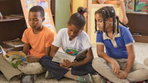Niños sentados en un salón de clases leyendo cuentos
