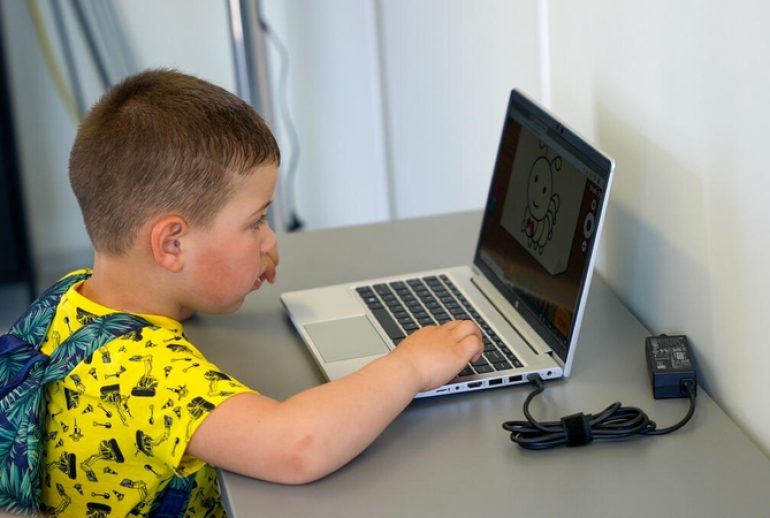 Ukrainian refugee Kiril, 4 is happy to be able to use a computer at the Portable Connectivity Center that World Vision has opened with its partners Geeks without Frontiers in Bucharest, Romania.